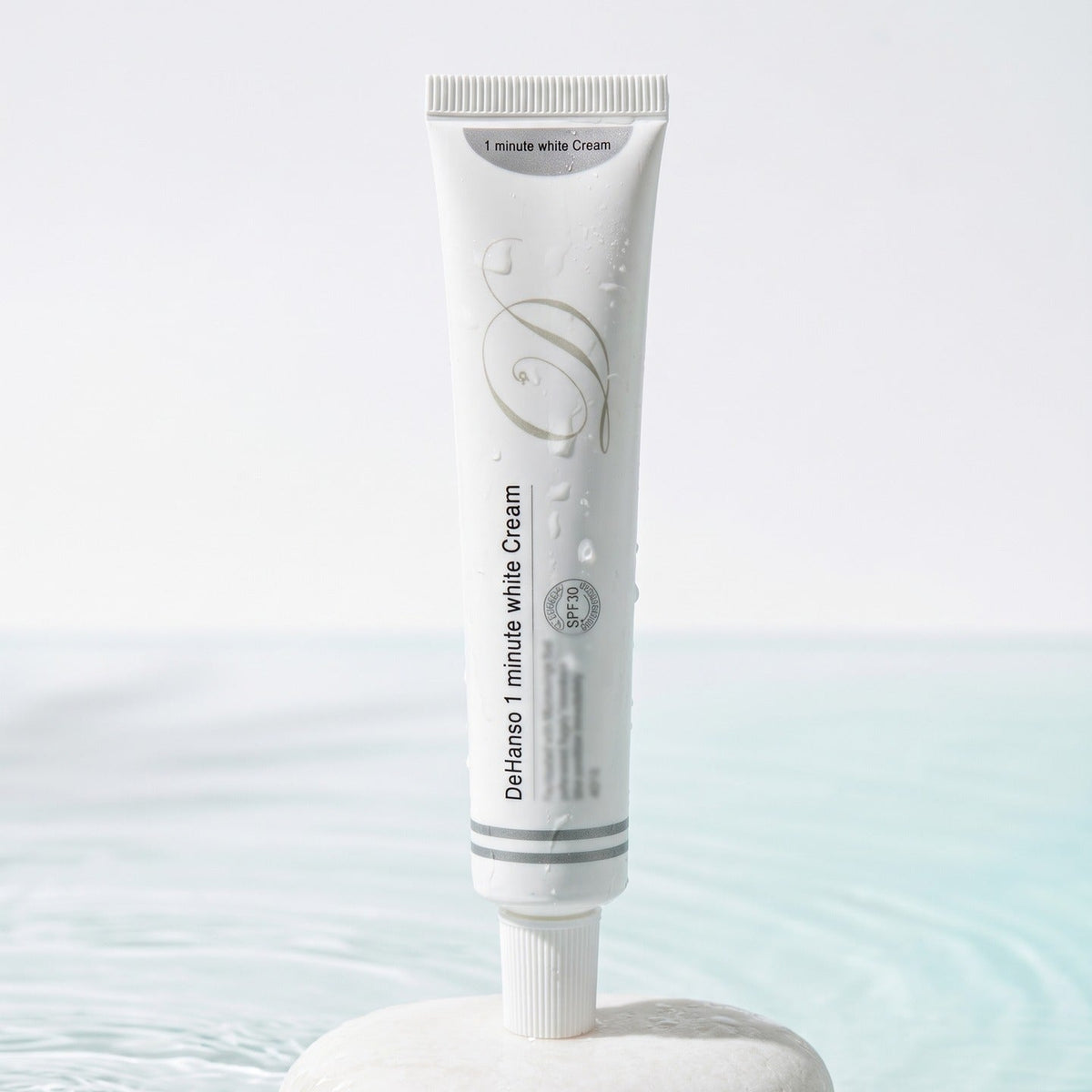 DeHanso 1 Minute White Cream SPF 30 tube on a white stone in water